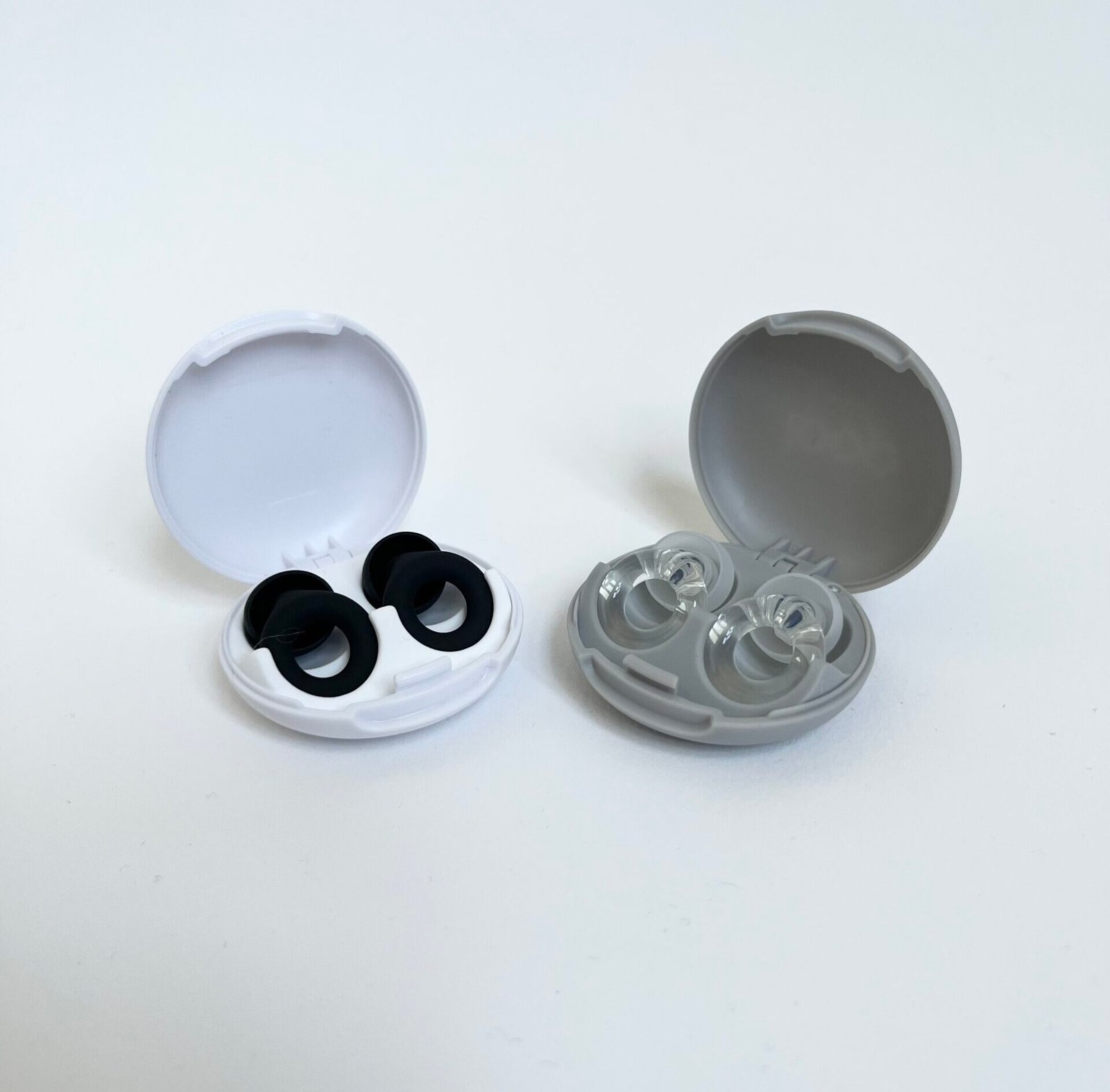 Loop Quiet 2 and Loop Engage carrying cases photographed side by side, both open showing the earplugs seated inside.