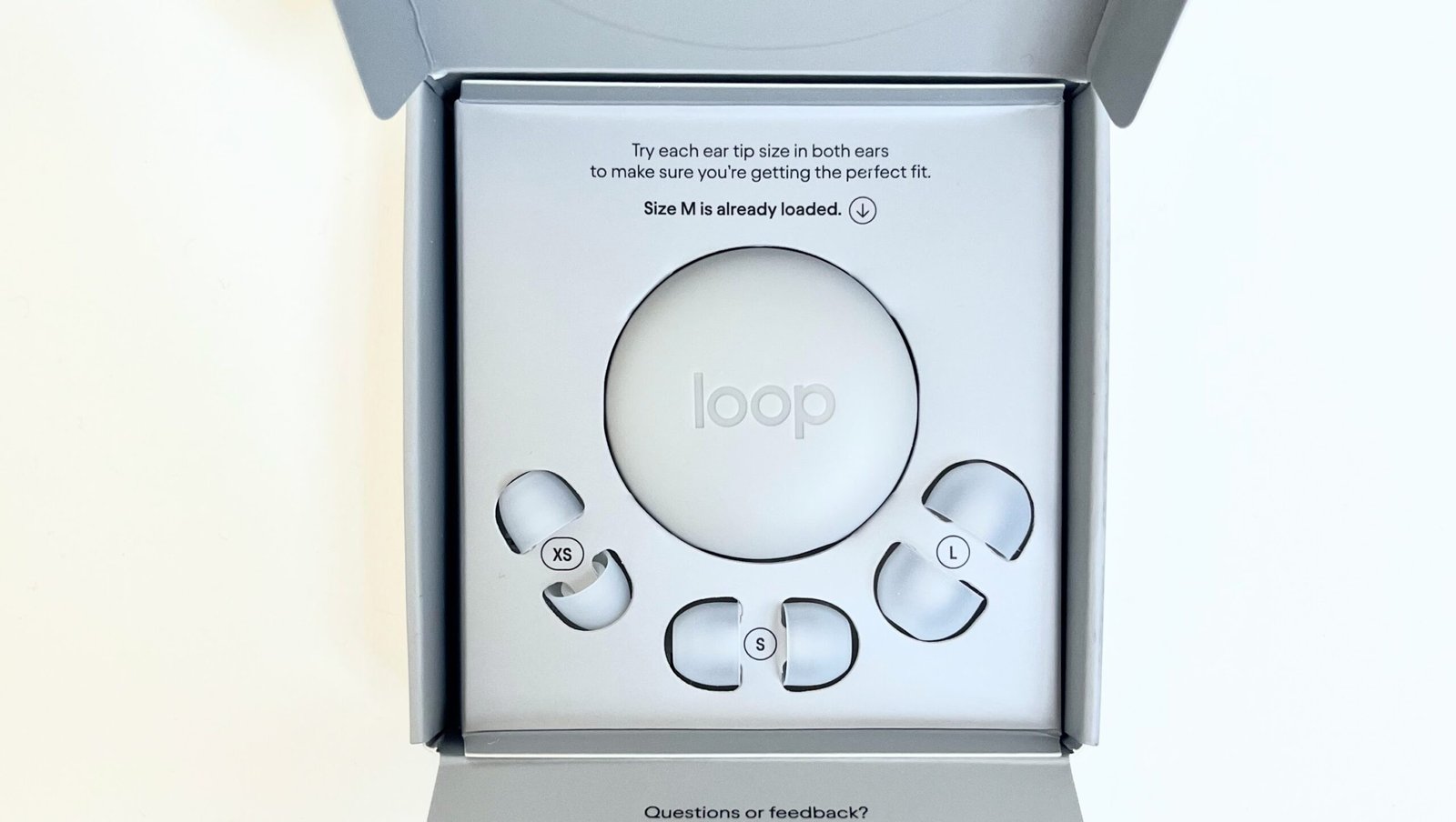 Loop Engage packaging opened to show the origami-style cardboard box and the translucent clear earplugs with visible mesh filter core inside.