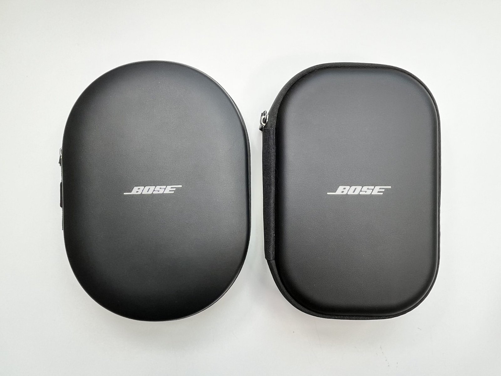 The Bose QuietComfort Ultra 2nd Gen carrying case beside the standard Bose QuietComfort case, photographed together for size comparison.